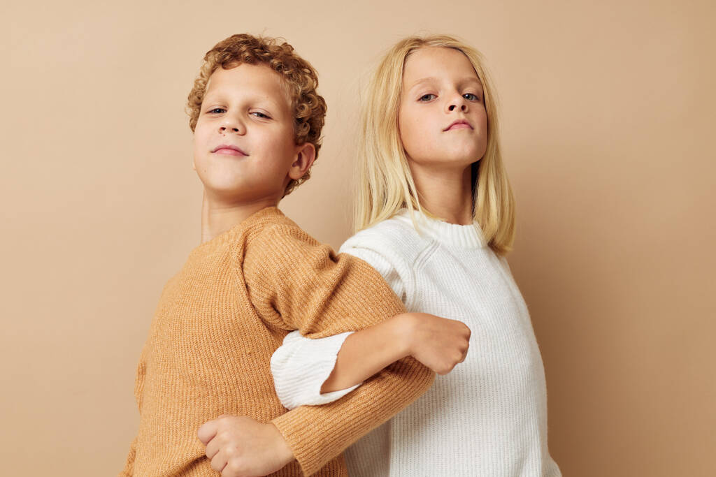 Garçon et fille debout à côté des émotions posant fond beige - Photo, image