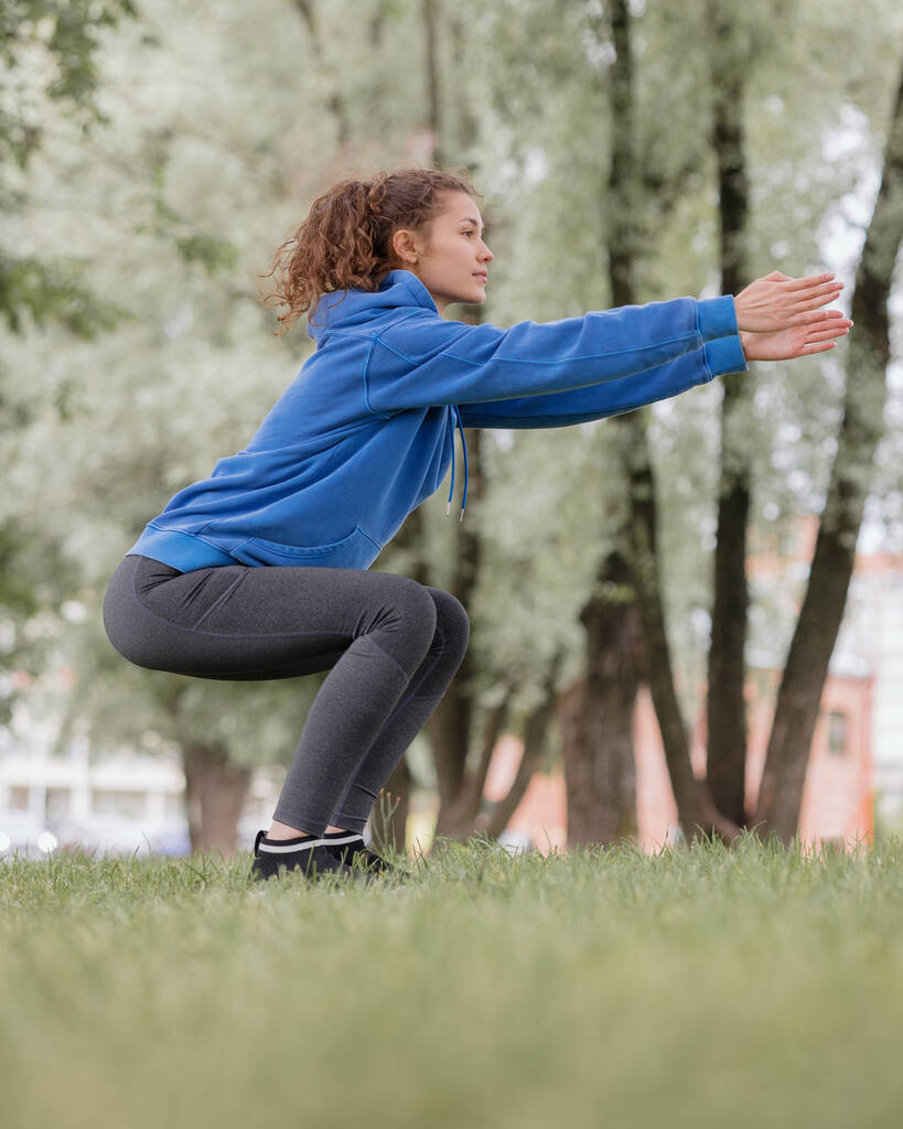 une femme européenne fait du sport dans un parc ou un lieu public. échauffement et jogging à l'air frais - Photo, image