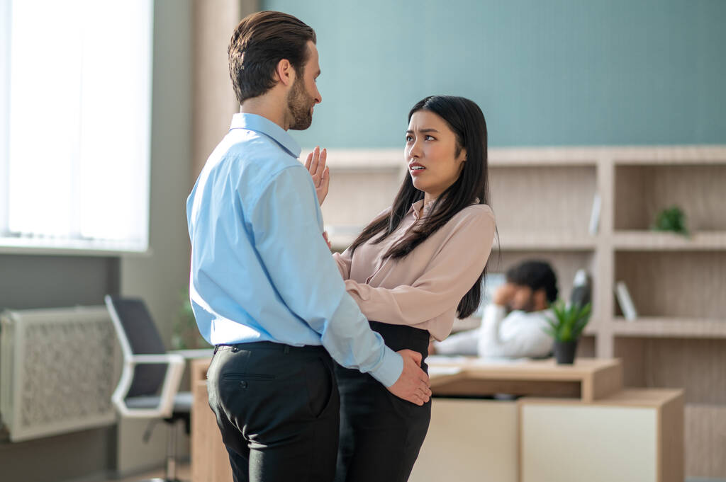 Man die zich ongepast gedraagt tegenover zijn vrouwelijke collega in het kantoor - Foto, afbeelding