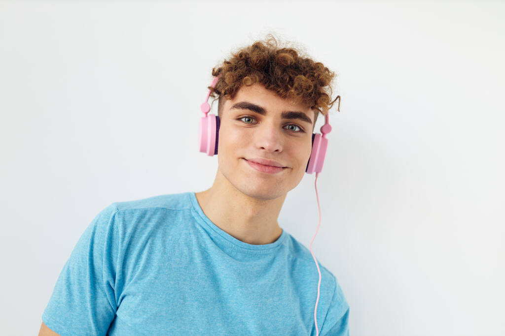 Attraktiver Mann in blauen T-Shirts rosa Kopfhörer Mode Lifestyle unverändert - Foto, Bild