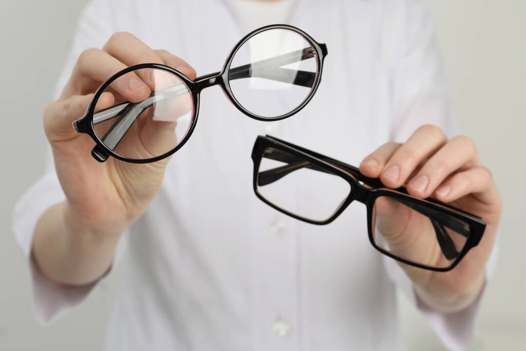 Mujer con gafas diferentes sobre fondo claro, primer plano - Foto, imagen