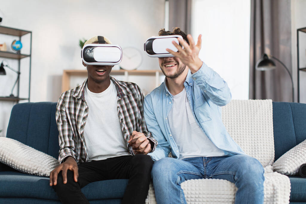 Ta sama para płci używa okularów VR podczas wolnego czasu w domu - Zdjęcie, obraz
