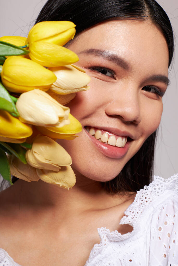 Portrait Asian beautiful young woman romance bouquet of flowers near the face studio model unaltered - Photo, Image