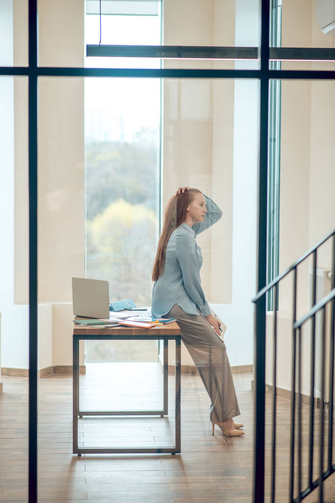 Přemýšlející žena opírající se o stůl v kanceláři - Fotografie, Obrázek