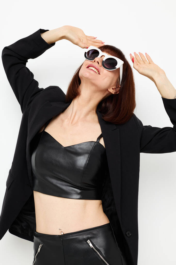 aantrekkelijke vrouw in een zwart jasje rode nagellak stijlvolle zonnebril Lifestyle onveranderd - Foto, afbeelding