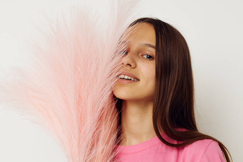 Милая молодая девушка в розовых перьях футболки позирует - Фото, изображение