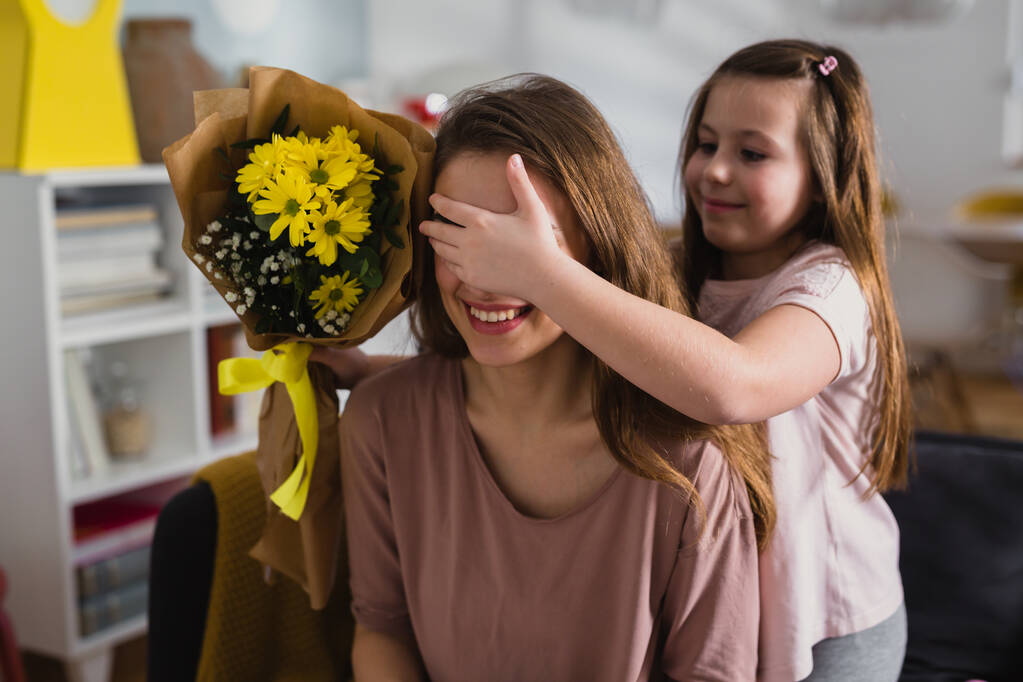 hija dando flores a su madre en casa - Foto, imagen