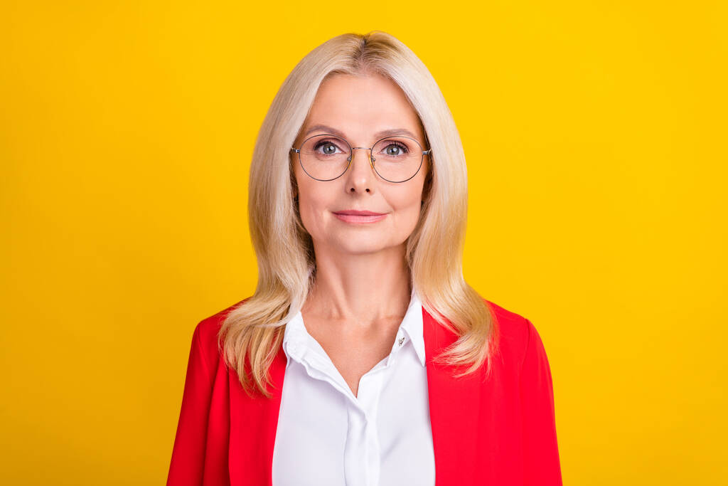 Foto de atraente idosa empresária inteligente agente de óculos gerente isolado sobre fundo de cor amarela. - Foto, Imagem