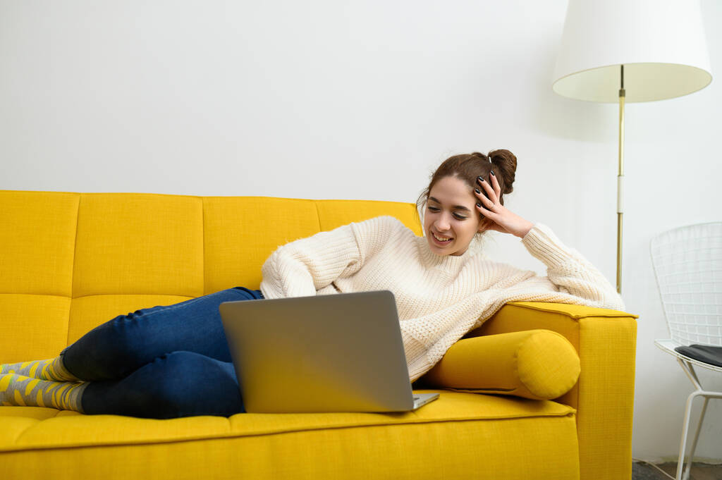 Egy fiatal nő laptopot használ távoli munkára vagy online tanulásra. - Fotó, kép