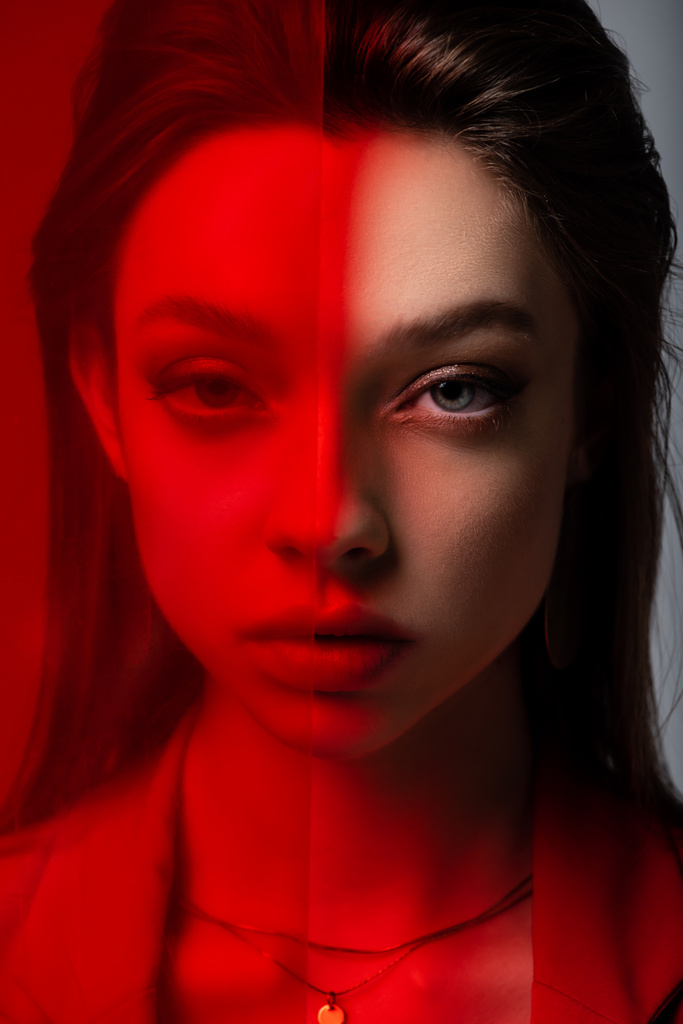 close up of young model looking at camera through red glass - Photo, Image