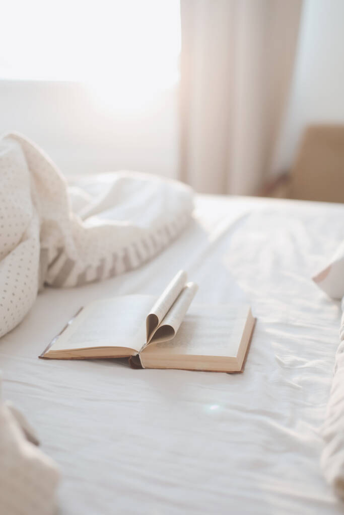 Lit du matin confortable avec un livre avec des pages pliées en forme de coeur - Photo, image