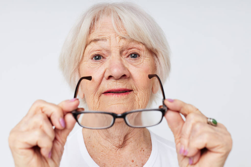 Zdjęcie emerytowanej starszej pani z problemami ze wzrokiem w okularach z bliska - Zdjęcie, obraz