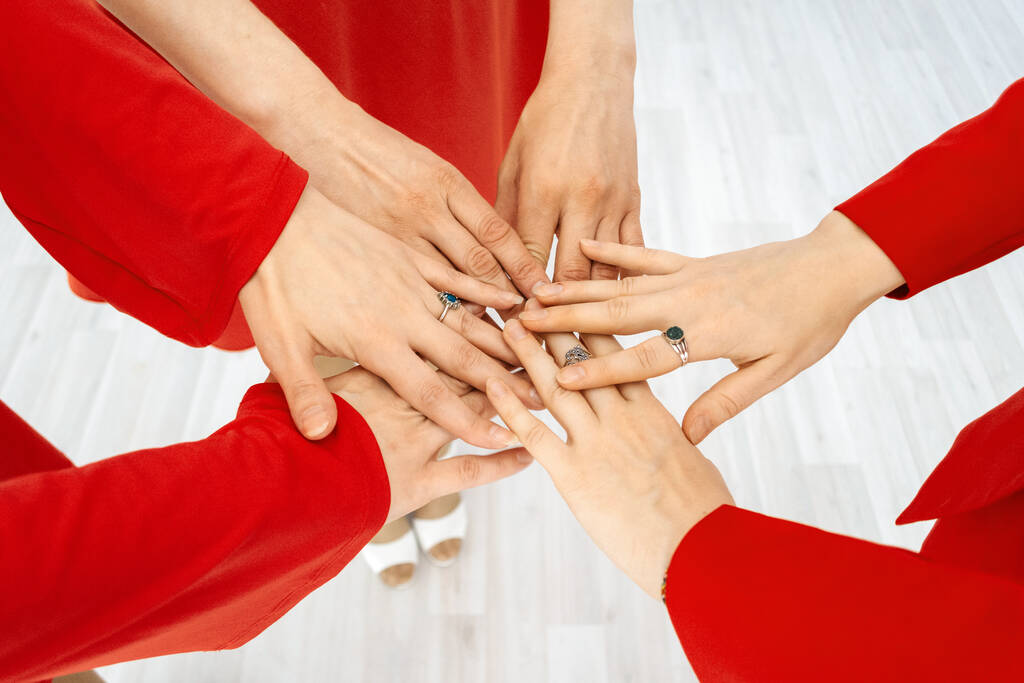 Женщины в красных платьях соединили руки - Фото, изображение