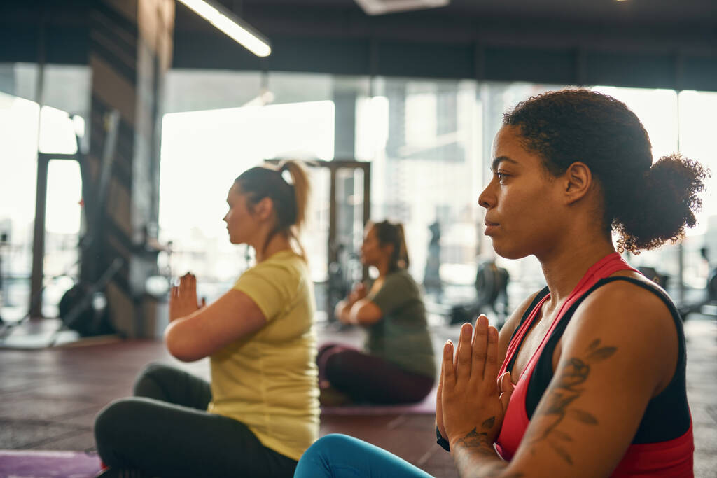Сосредоточься на девушке, практикующей йогу с размытыми женщинами - Фото, изображение