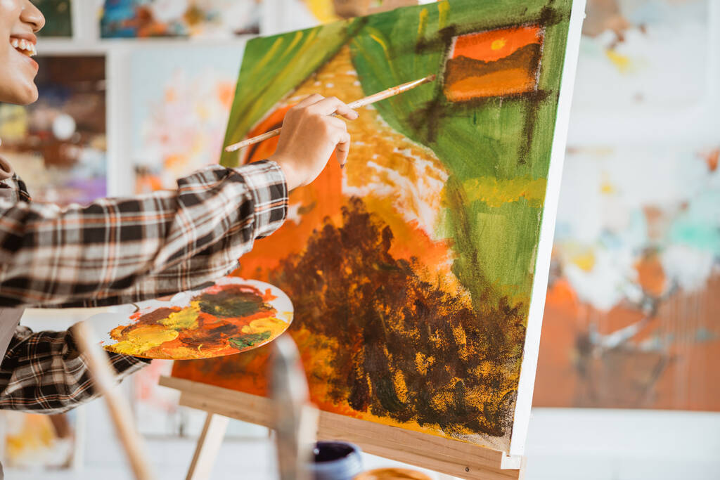 artistas femeninos sosteniendo a mano un pincel de pintura con paleta de colores en estudio - Foto, imagen
