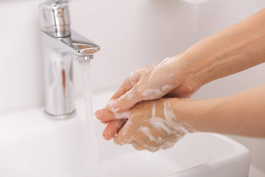 Πλένεις τα χέρια σου κάτω από τη βρύση. Πλύσιμο χεριών τρίψιμο με σαπούνι για την πρόληψη του ιού του στέμματος, υγιεινή για να σταματήσει η εξάπλωση του ιού του στέμματος στο δωμάτιο ή δημόσια πλύση. Στοιχεία του χεριού έννοιας της υγιεινής - Φωτογραφία, εικόνα