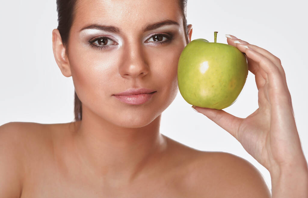 mladá krásná žena jíst zelené jablko izolovaných na bílém - Fotografie, Obrázek