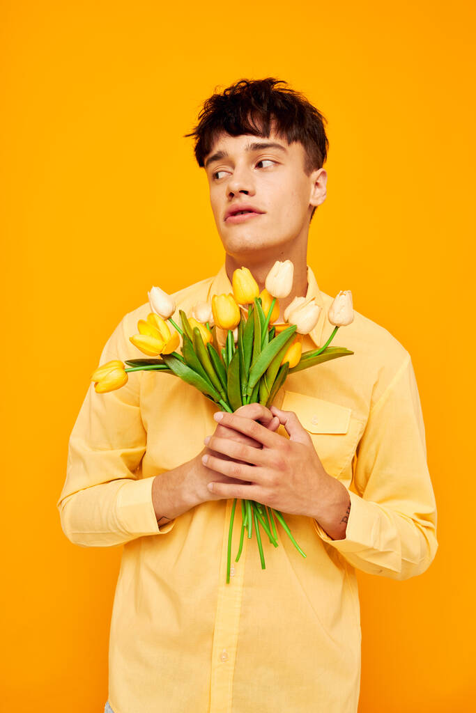 joli homme avec un bouquet de fleurs posant un cadeau Lifestyle inchangé - Photo, image