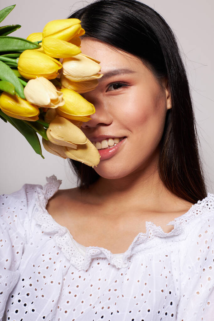 Portré ázsiai szép fiatal nő virágok tavasz pózol fény háttér változatlan - Fotó, kép