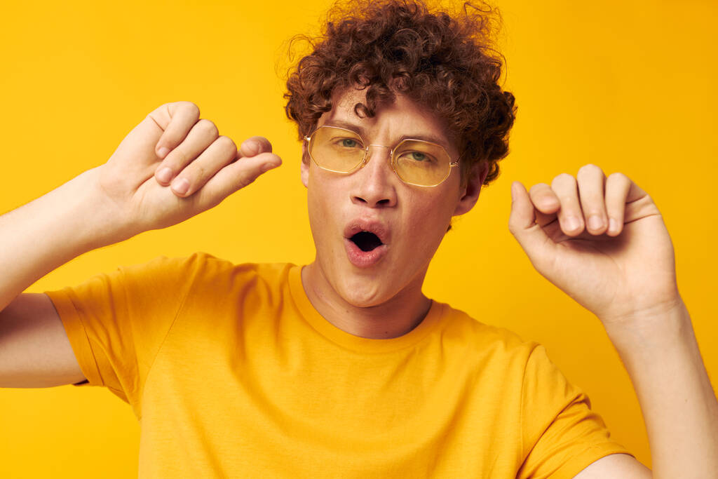 lindo pelirrojo chico usando gafas con estilo amarillo camiseta posando monocromo tiro - Foto, Imagen