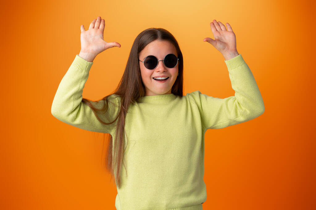 Engraçado caucasiano adolescente menina em óculos isolados no fundo laranja - Foto, Imagem