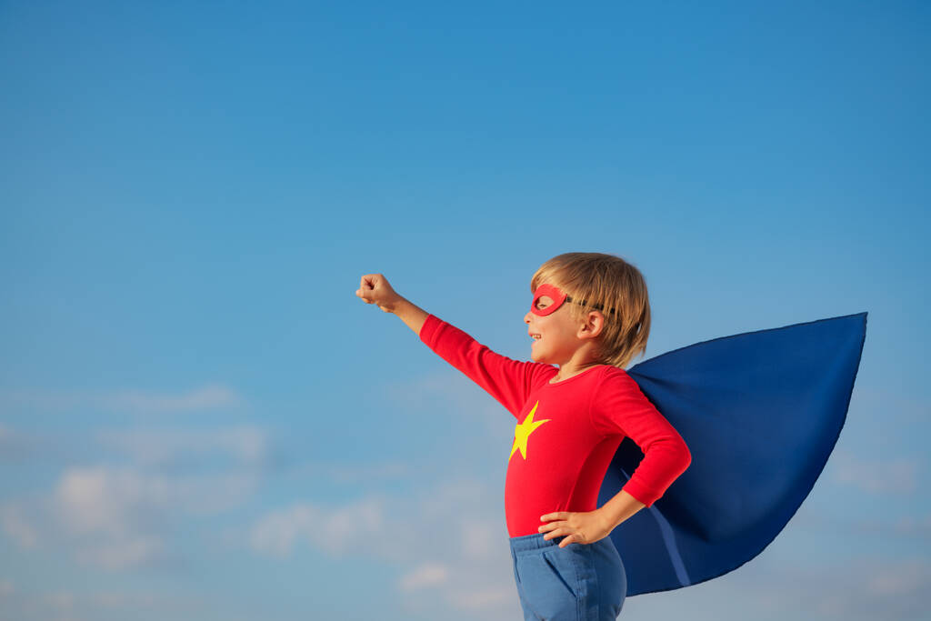 Супергеройська дитина грає на відкритому повітрі. Супер герой дитина на тлі блакитного літнього неба. Уява і концепція свободи
 - Фото, зображення