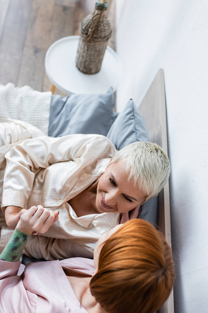 Yleisnäkymä lesbo naiset kädestä sängyllä kotona  - Valokuva, kuva