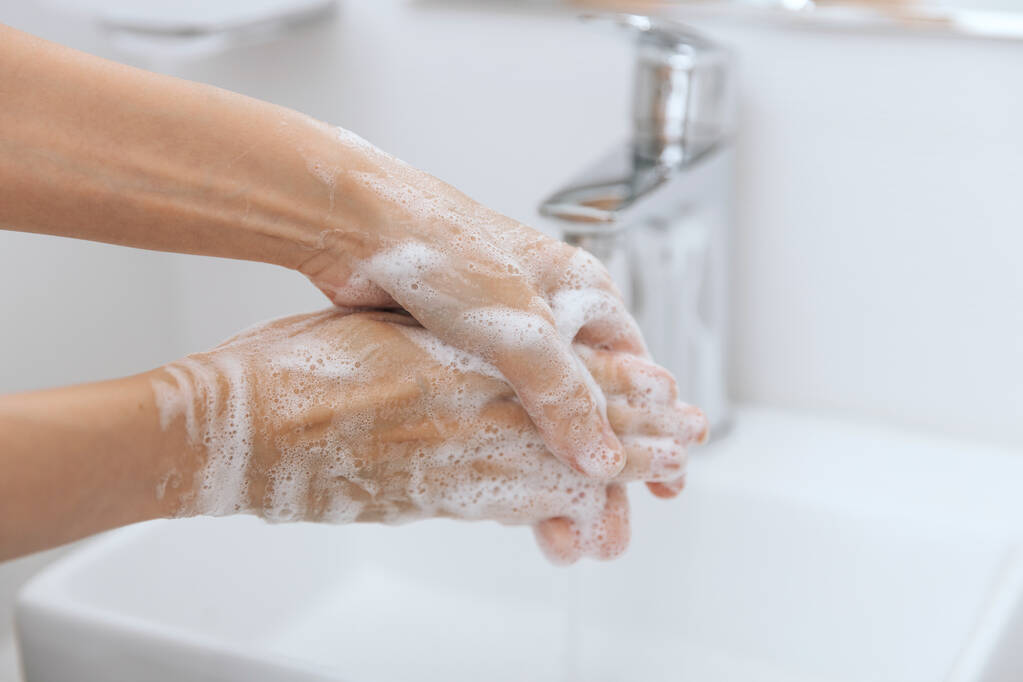 Se laver les mains sous le robinet d'eau courante. Se laver les mains en frottant avec du savon pour prévenir le virus de la couronne, l'hygiène pour arrêter la propagation du virus de la couronne dans les toilettes publiques. Concept d'hygiène détail des mains - Photo, image