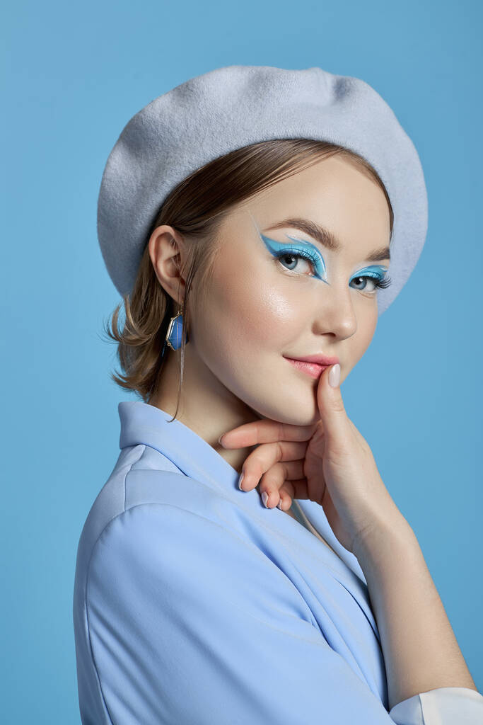 Beleza retrato de uma mulher com olhos azuis, um vestido azul e um fundo azul. Maquiagem de arte Maquiagem profissional e cosméticos para o rosto. Estilo sofisticado retrato de arte - Foto, Imagem