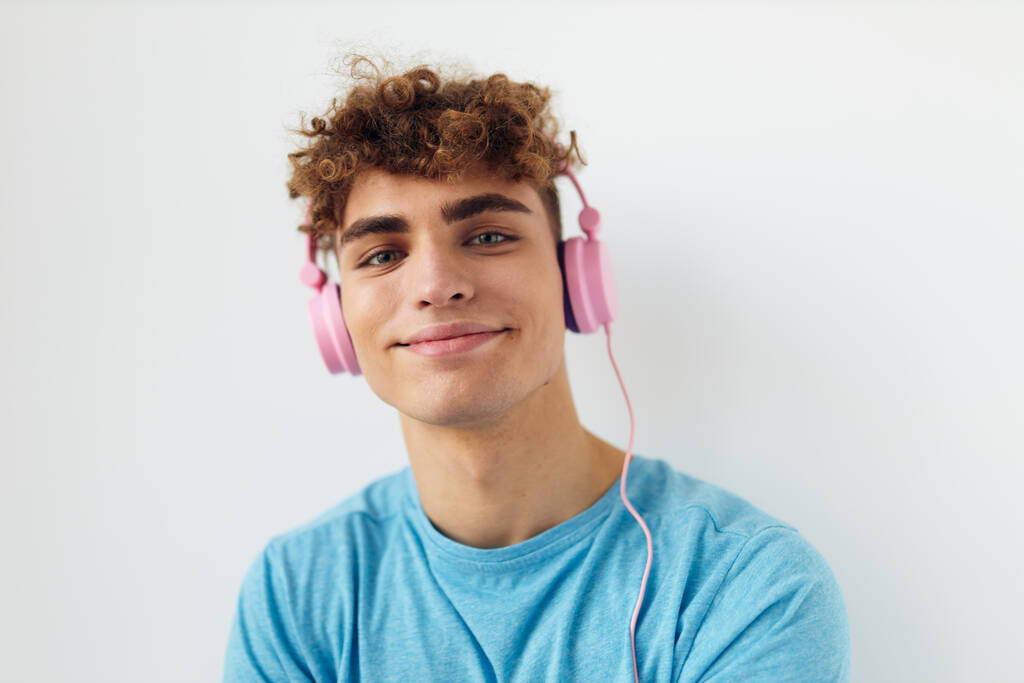 bonito jovem homem em azul t-shirts rosa fones de ouvido moda isolado fundo - Foto, Imagem