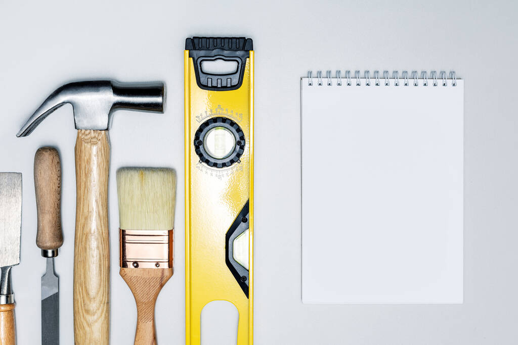 Different construction tools and notebook on grey surface.  building tools, construction buildings, repair concept. - Photo, Image