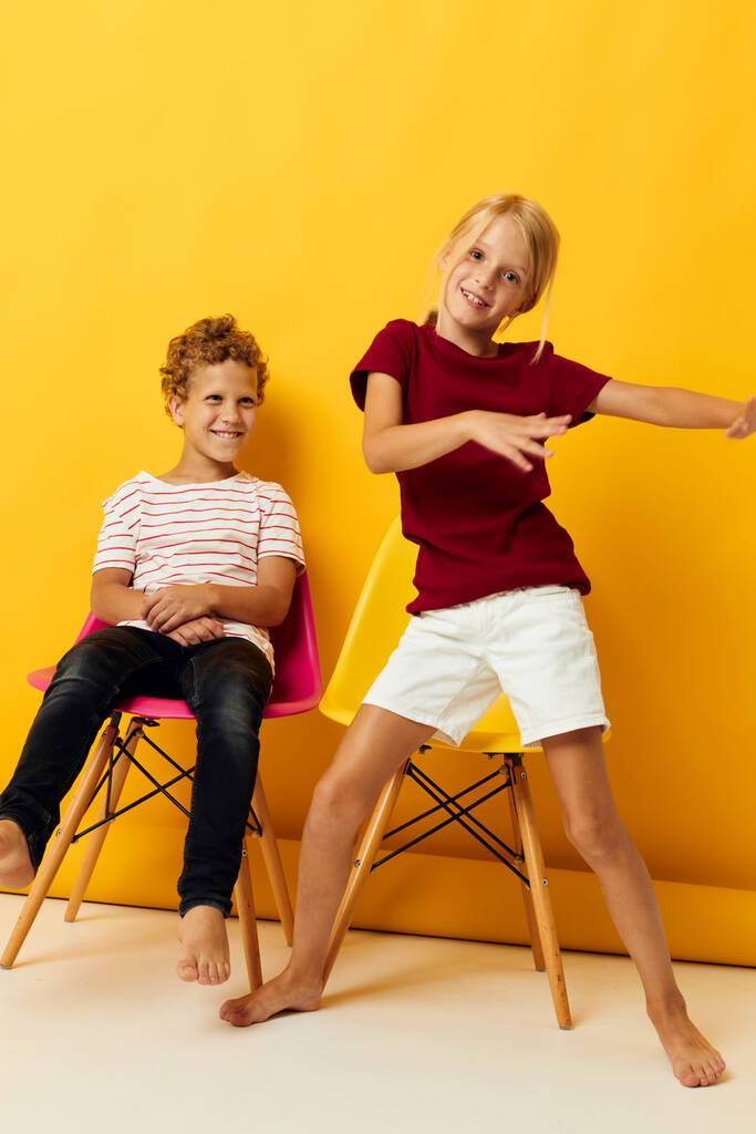 Маленькі діти дитинство сидить на стільцях разом на кольоровому фоні
 - Фото, зображення