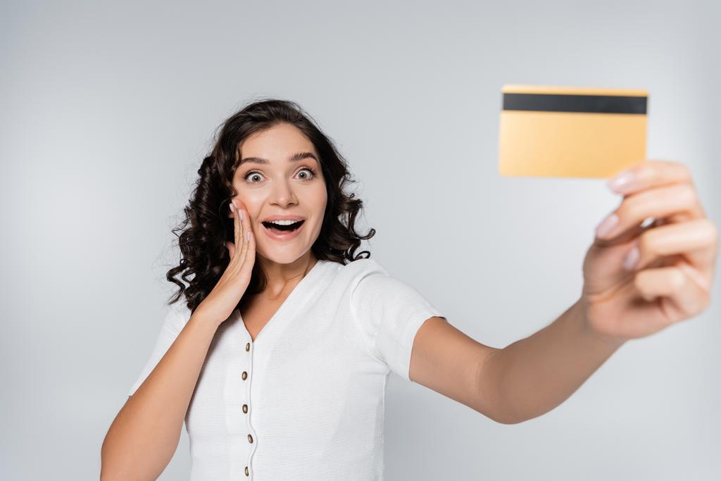 excité femme tenant carte de crédit avec cashback isolé sur gris - Photo, image
