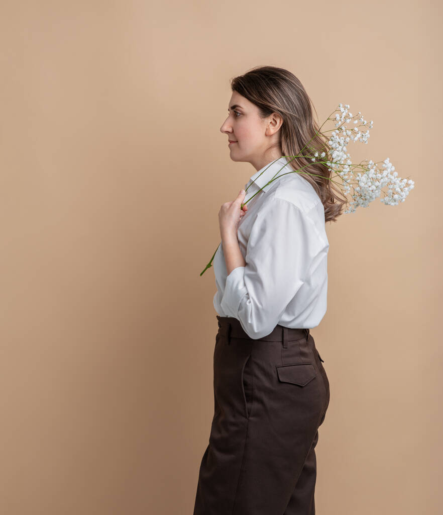 retrato de mujer pensativa sosteniendo rama de flor - Foto, imagen
