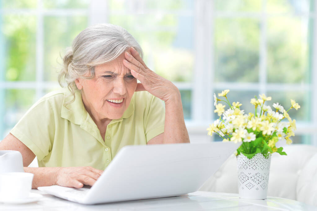 mulher sênior confuso usando laptop em casa - Foto, Imagem