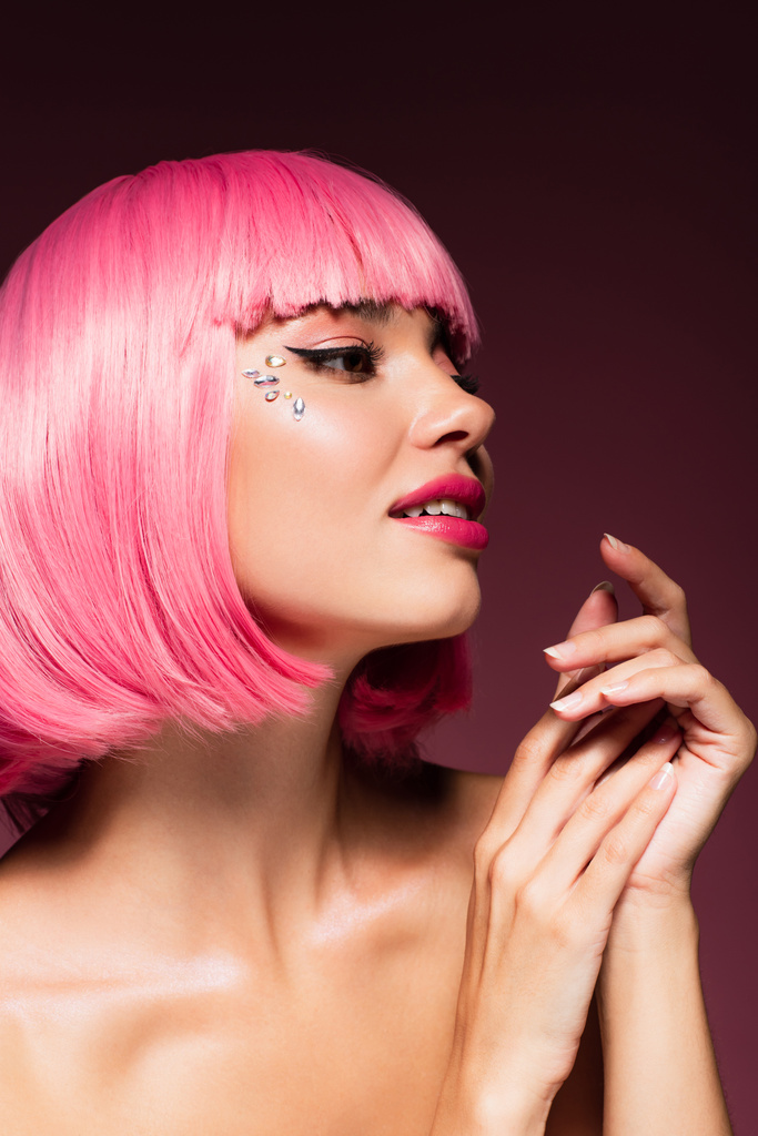 sensual jovem mulher com cabelo rosa e pedras brilhantes no rosto em roxo escuro - Foto, Imagem