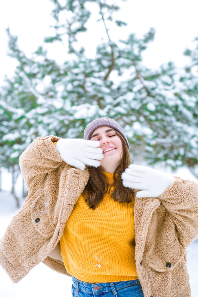 Mladá roztomilá dívka se baví ve sněžném počasí v zimě v parku. Životní styl  - Fotografie, Obrázek