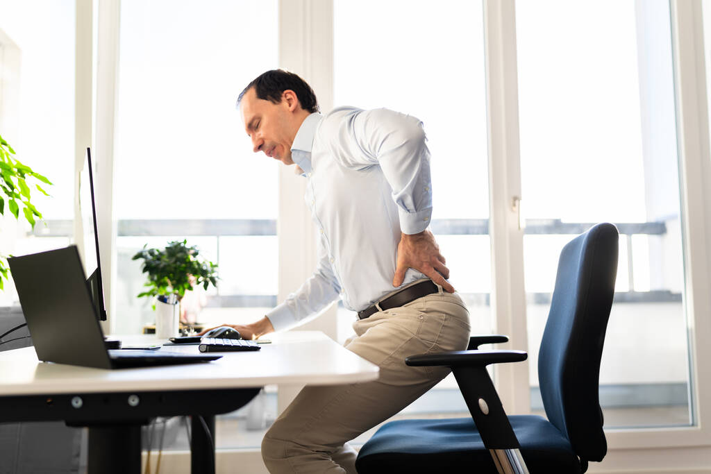 Mal di schiena Male postura uomo seduto in ufficio - Foto, immagini