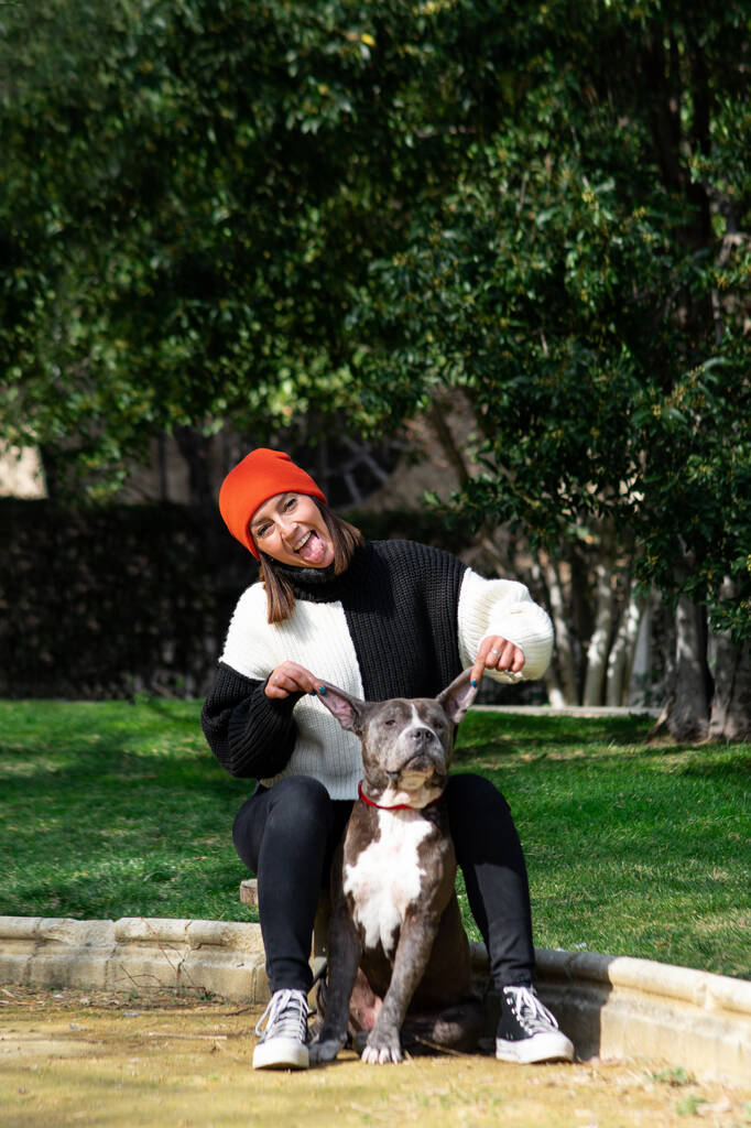 Νεαρή κοπέλα με το σκύλο της στο πάρκο το καλοκαίρι - Φωτογραφία, εικόνα
