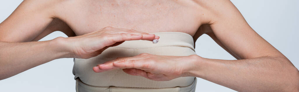 bijgesneden beeld van vrouw van middelbare leeftijd aanbrengen crème gel op de hand geïsoleerd op grijs, banner - Foto, afbeelding