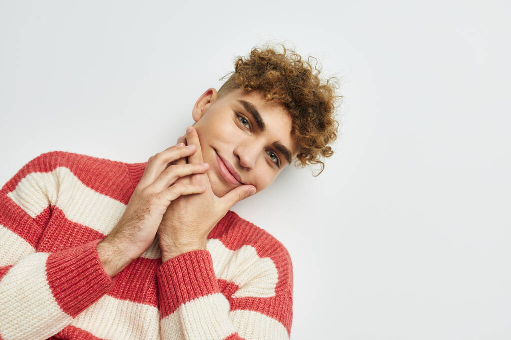 rizado chico en un rayas suéter posando luz de fondo - Foto, imagen