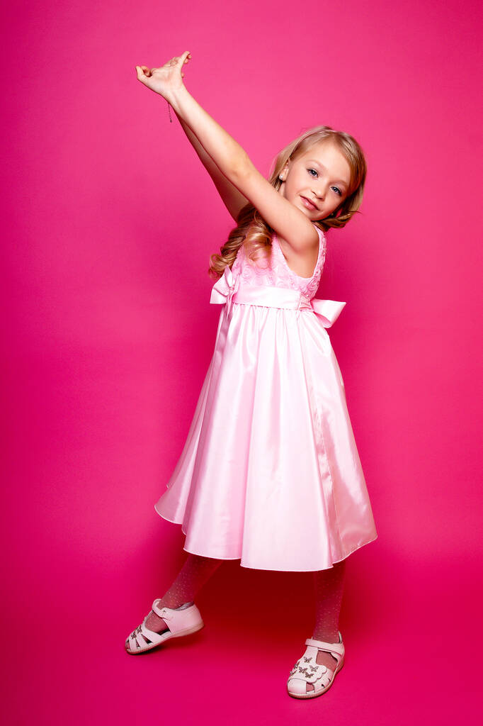Όμορφο νεαρό κορίτσι με ροζ φόρεμα. Απομονωμένο στούντιο πυροβόλησε - Φωτογραφία, εικόνα