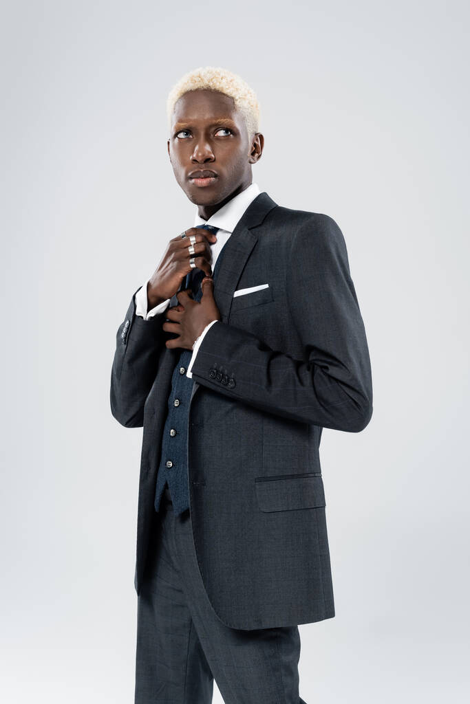 rubia africano americano hombre en formal desgaste ajuste corbata aislado en gris  - Foto, Imagen