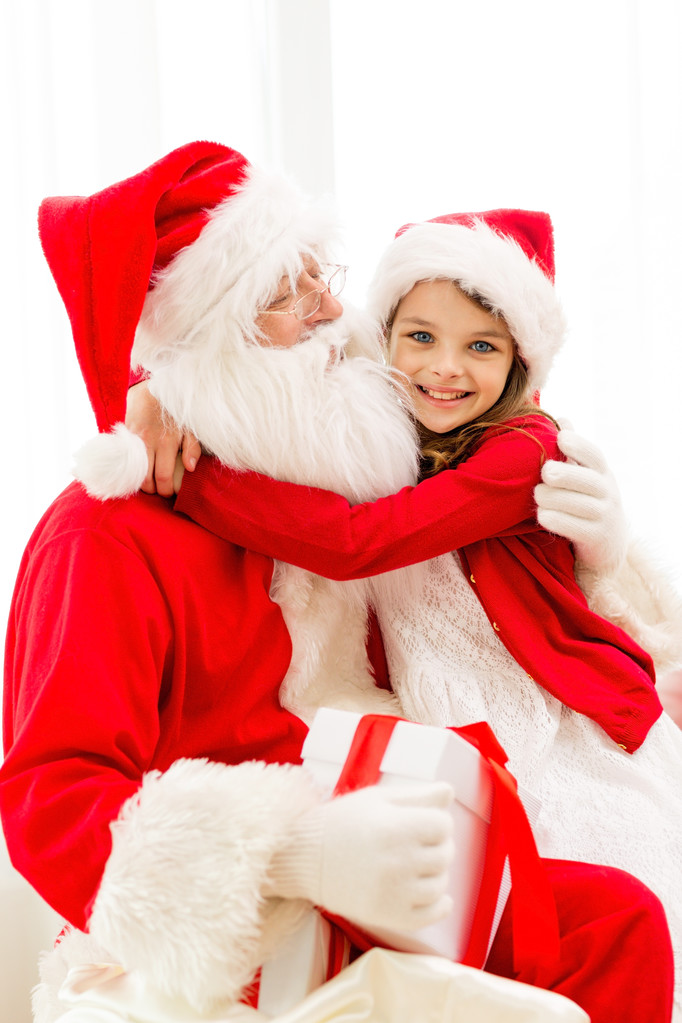 sorridente ragazza con Babbo Natale e regalo a casa
 - Foto, immagini