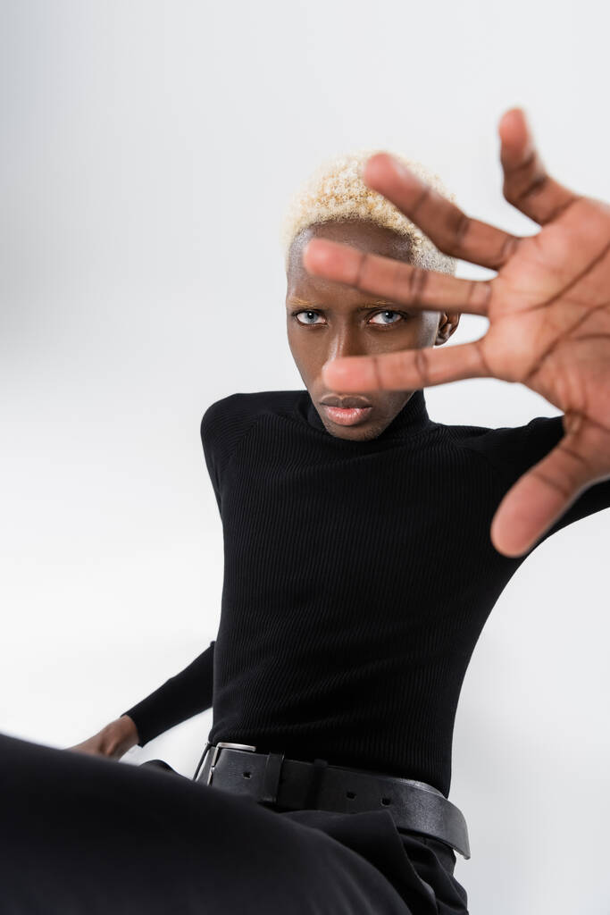 блондинка афроамериканський молодий чоловік жестикулює ізольовано на сірому
  - Фото, зображення
