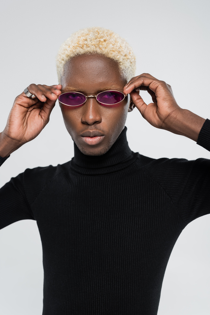 blonde african american man in turtleneck wearing pink sunglasses isolated on grey - Photo, Image