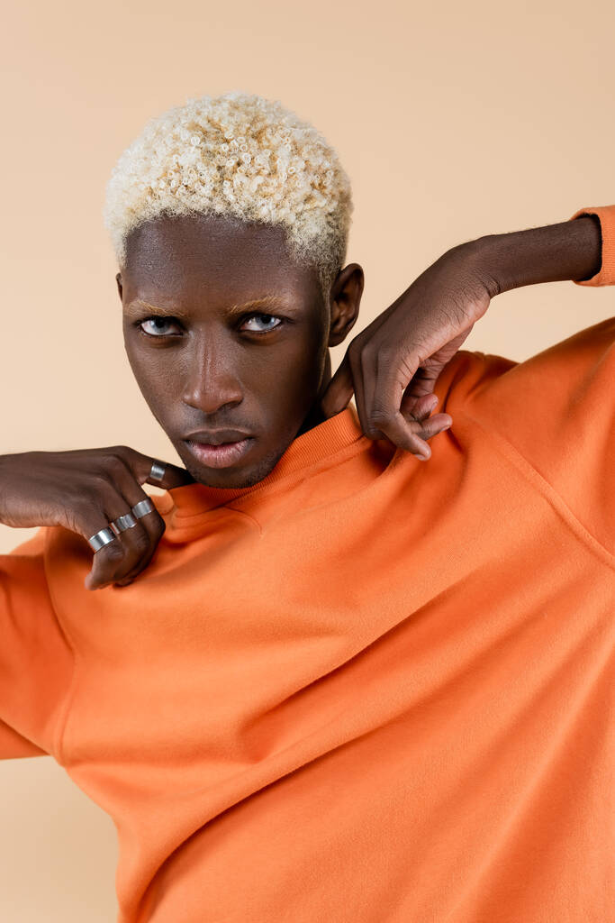 blonde african american man with blue eyes looking at camera isolated on beige  - Photo, Image