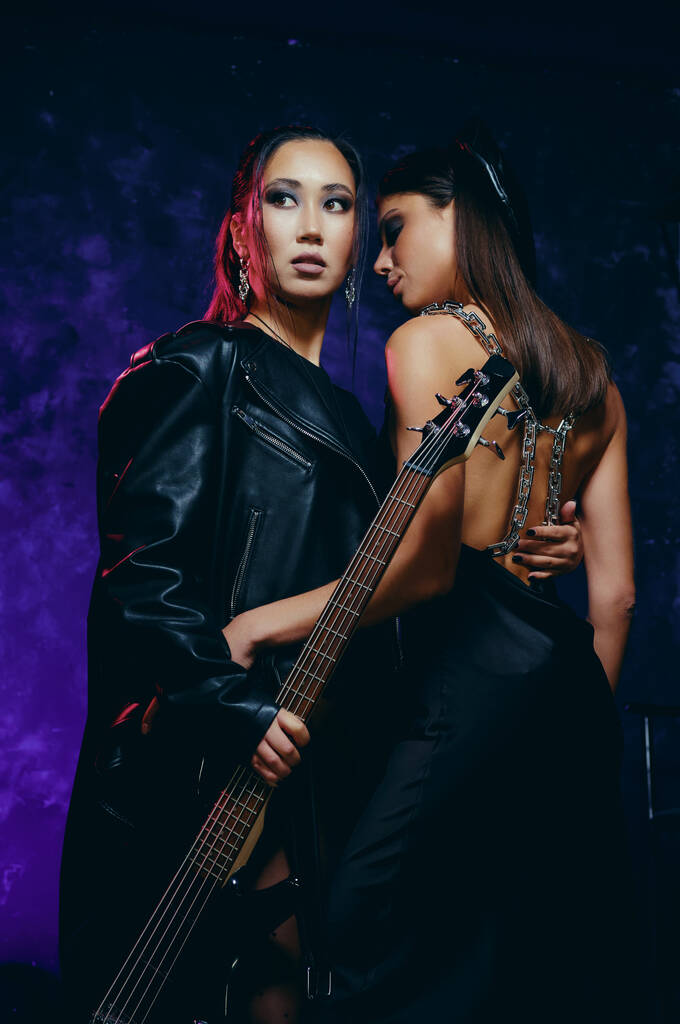 Dos hermosas mujeres jóvenes usan ropa de moda posando con la guitarra en el interior, tiro al estudio. Concepto de moda y belleza - Foto, Imagen