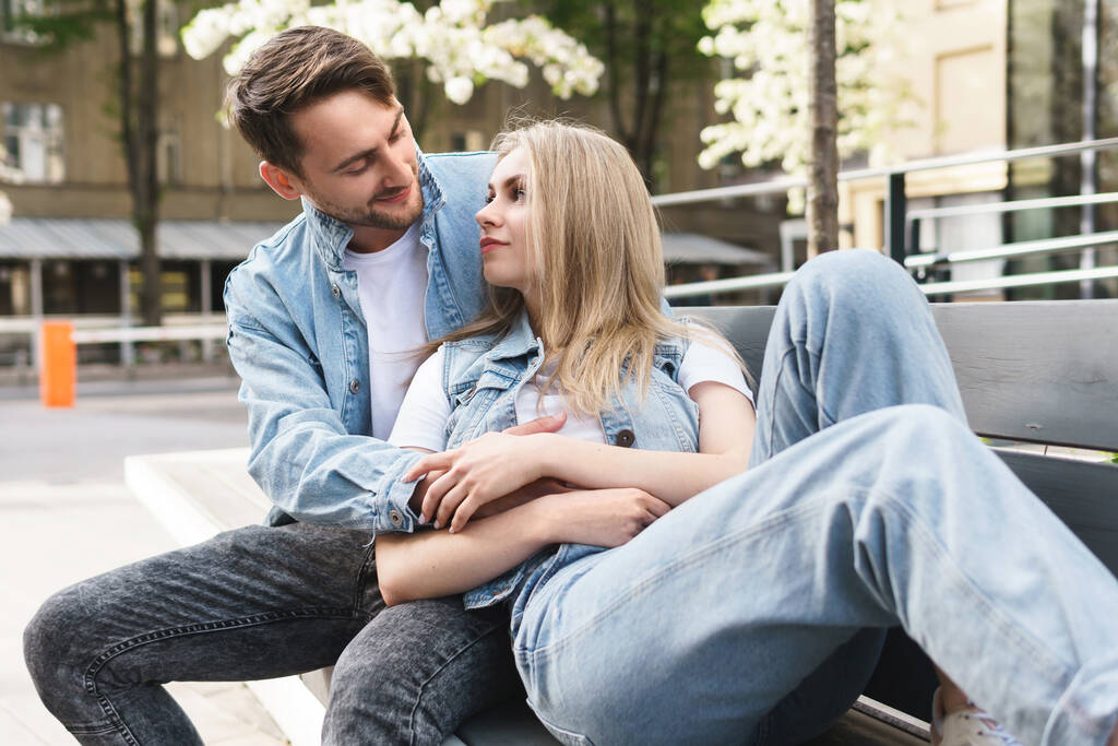 Портрет молодої чуттєвої і люблячої пари, що сидить на лавці під час побачення на відкритому повітрі
 - Фото, зображення