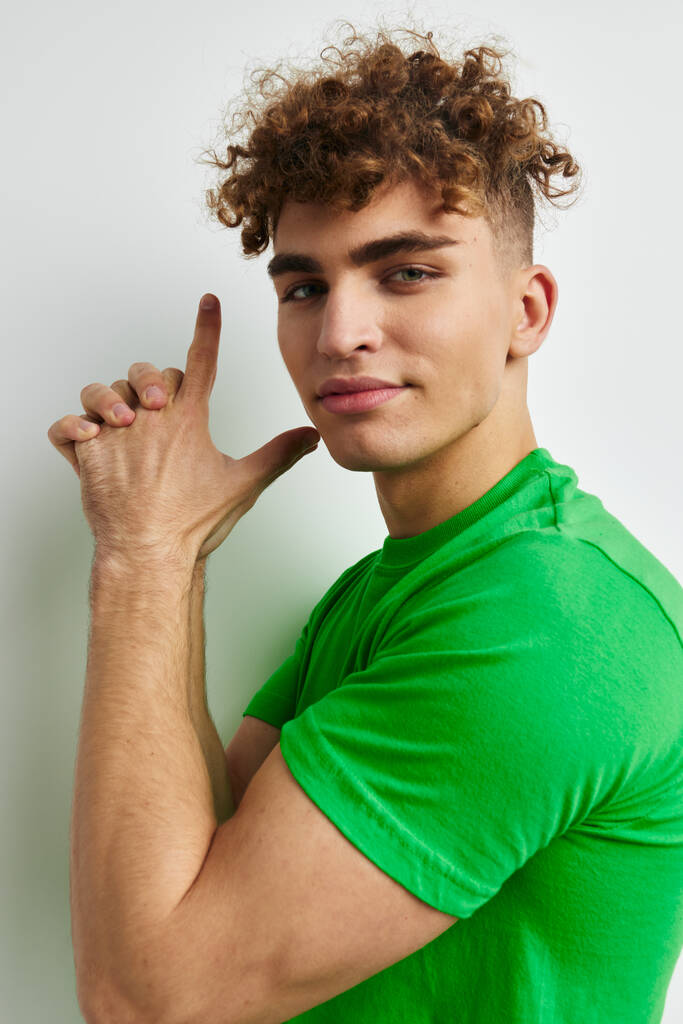 bel ragazzo in verde t-shirt emozioni posa sfondo isolato - Foto, immagini
